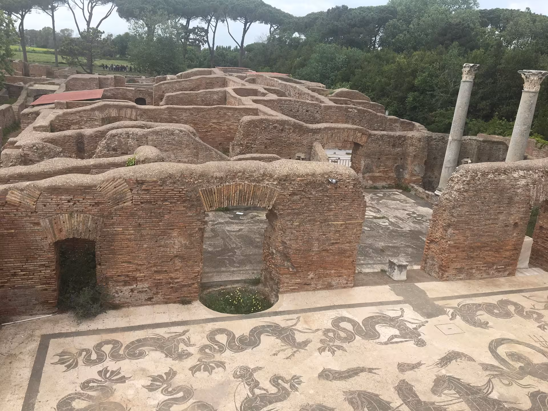 Ruins of Ancient Ostia with intricate mosaics and towering columns, showcasing Roman history on the vintage tour.