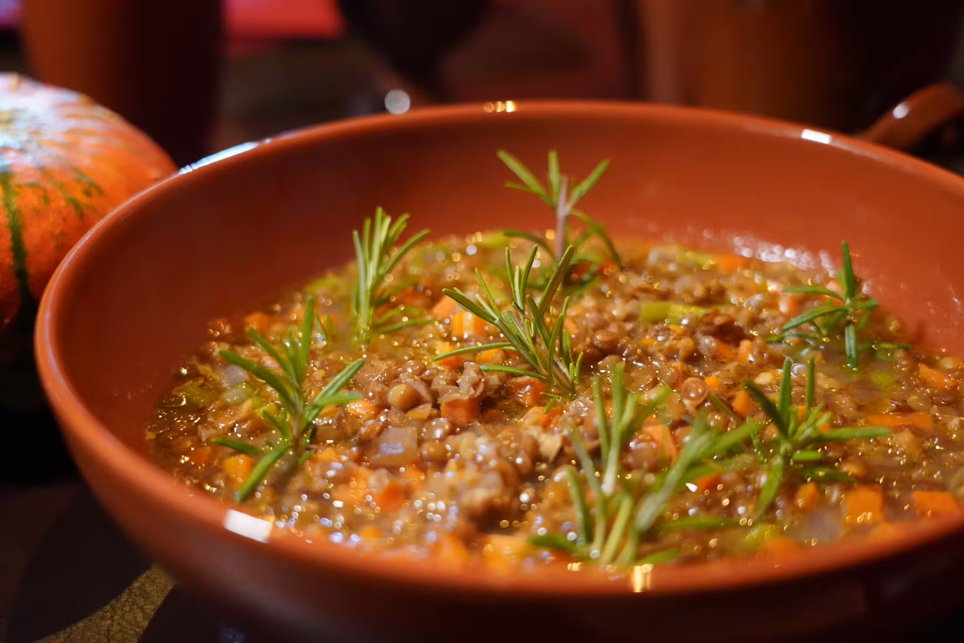 Close-up of hearty ancient Roman-style lentil stew with vegetables and fresh rosemary served during Lunch in the Ancient Pompeii tour