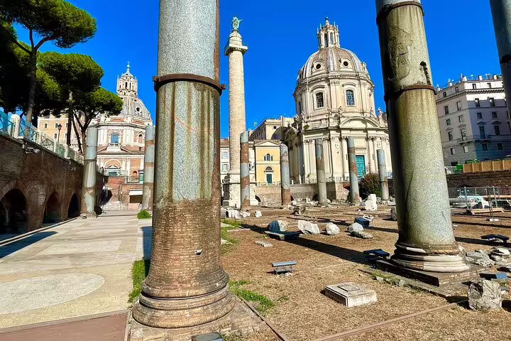 Ancient columns and Trajan’s Column framing baroque churches near the Roman Forum on a guided panoramic Rome tour