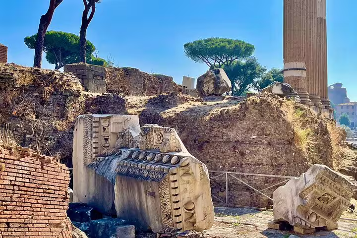 Ancient marble ruins and temple column in the Roman Forum under clear blue skies on a guided Palatine Hill history tour