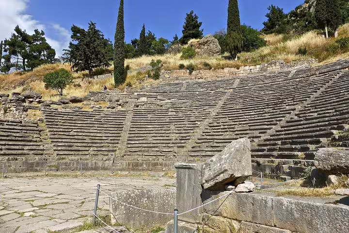 Ancient theatre of Delphi with stone seating on hillside, highlight of private Delphi tour from Athens