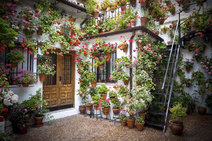 A charming Andalusian courtyard adorned with vibrant flowers and traditional Spanish architecture.
