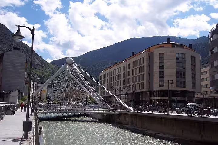 Modern suspension bridge over river in Andorra la Vella with mountain backdrop, ideal for scenic Andorra tours.