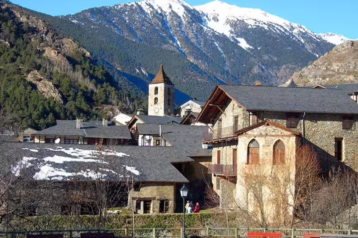 Charming village in Andorra nestled in the Pyrenees with traditional stone houses and snow-capped mountains.