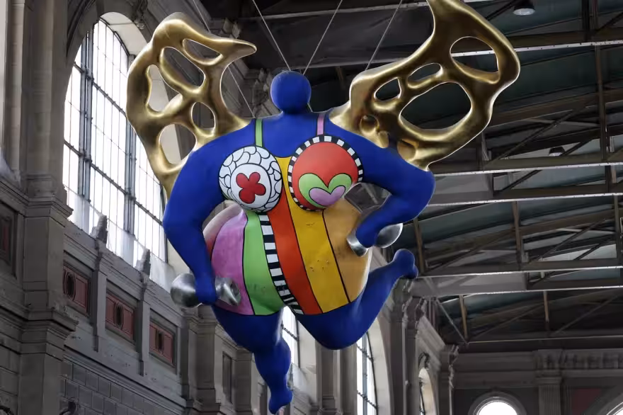 Colorful angel sculpture inside Zurich station, a highlight before your Glacier Express route private tour from Zurich