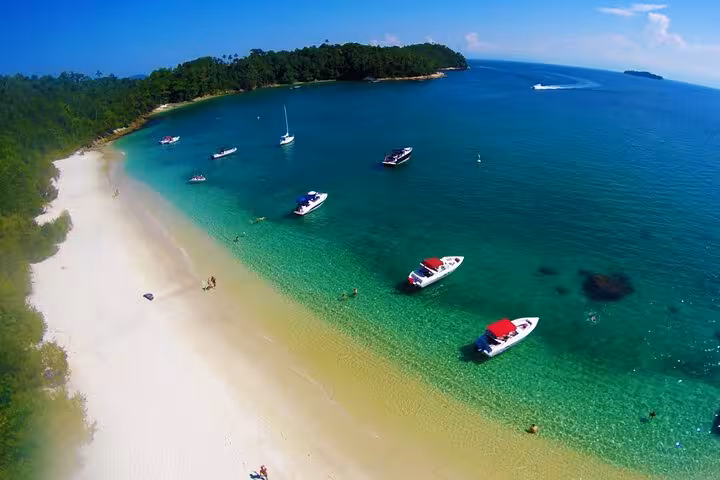 Aerial view of pristine beach and anchored boats in Angra dos Reis, perfect for private boat tours in Paradise Islands.