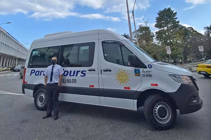Paraty Tours driver standing beside a shuttle van, ensuring safe travel from Angra dos Reis to Paraty.
