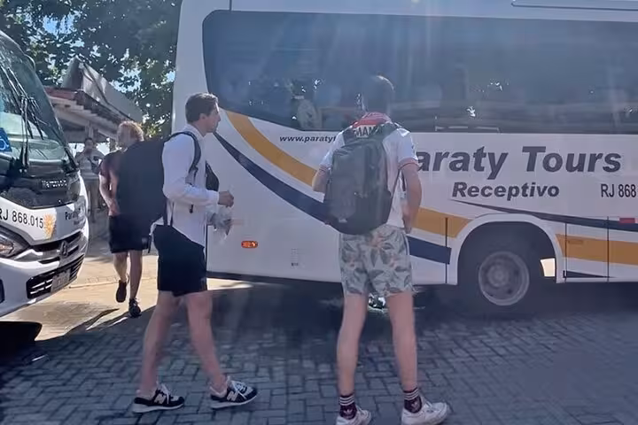 Passengers preparing to board a Paraty Tours bus in Angra dos Reis for a shared transfer to Rio de Janeiro.