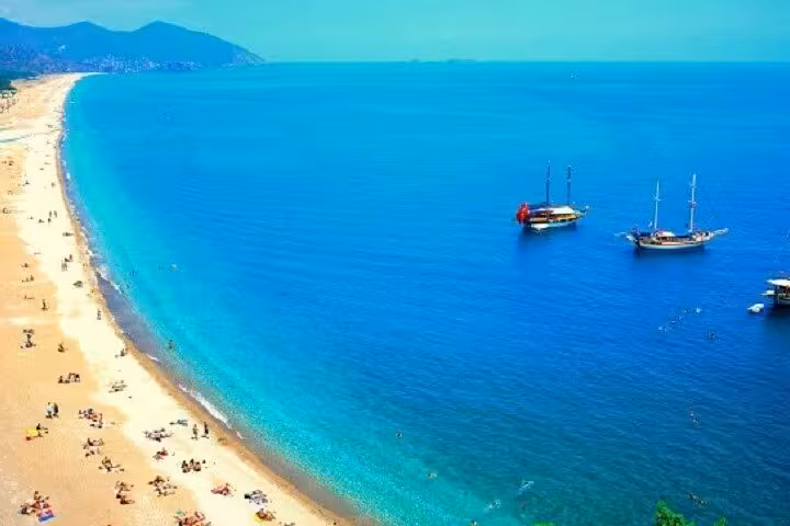 Turquoise Mediterranean coast and boats off Antalya beach, relaxing stop on 8-day Turkey tour package
