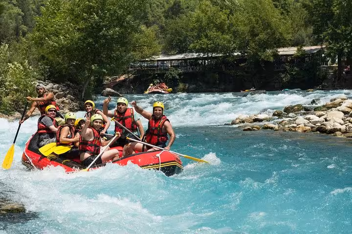Smiling rafters in life jackets on turquoise rapids at Köprülü Canyon during Antalya rafting tour