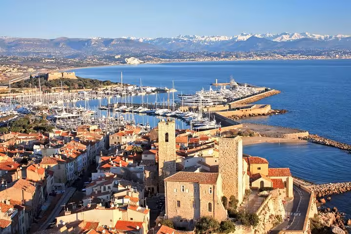 Scenic view of Antibes harbor with yachts and historic buildings along the French Riviera coastline.