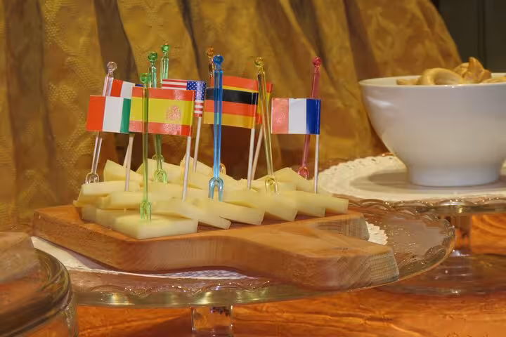 Assorted cheese with international flags offer a delightful aperitivo experience on the Monte Cassino Gustav Wine tour.