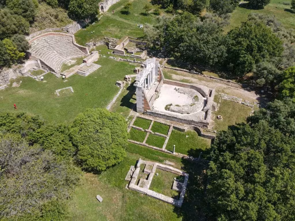 Aerial view of Apollonia's ancient ruins surrounded by lush greenery on a day trip from Tirana to Berat.