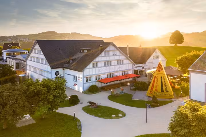 Sunset view of a traditional Swiss building in Appenzell, featuring a cheese-themed garden on the St. Gallen tour.