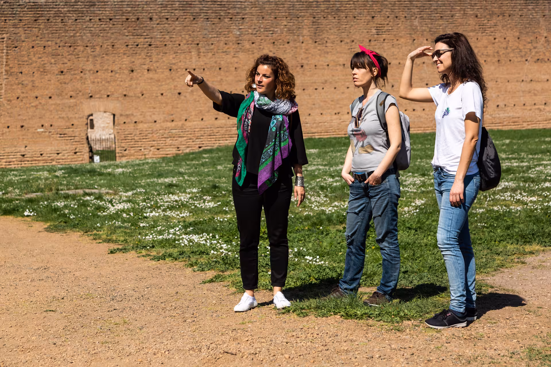 Guided tour exploring ancient ruins along the Appian Way with a knowledgeable guide pointing out historical sites.