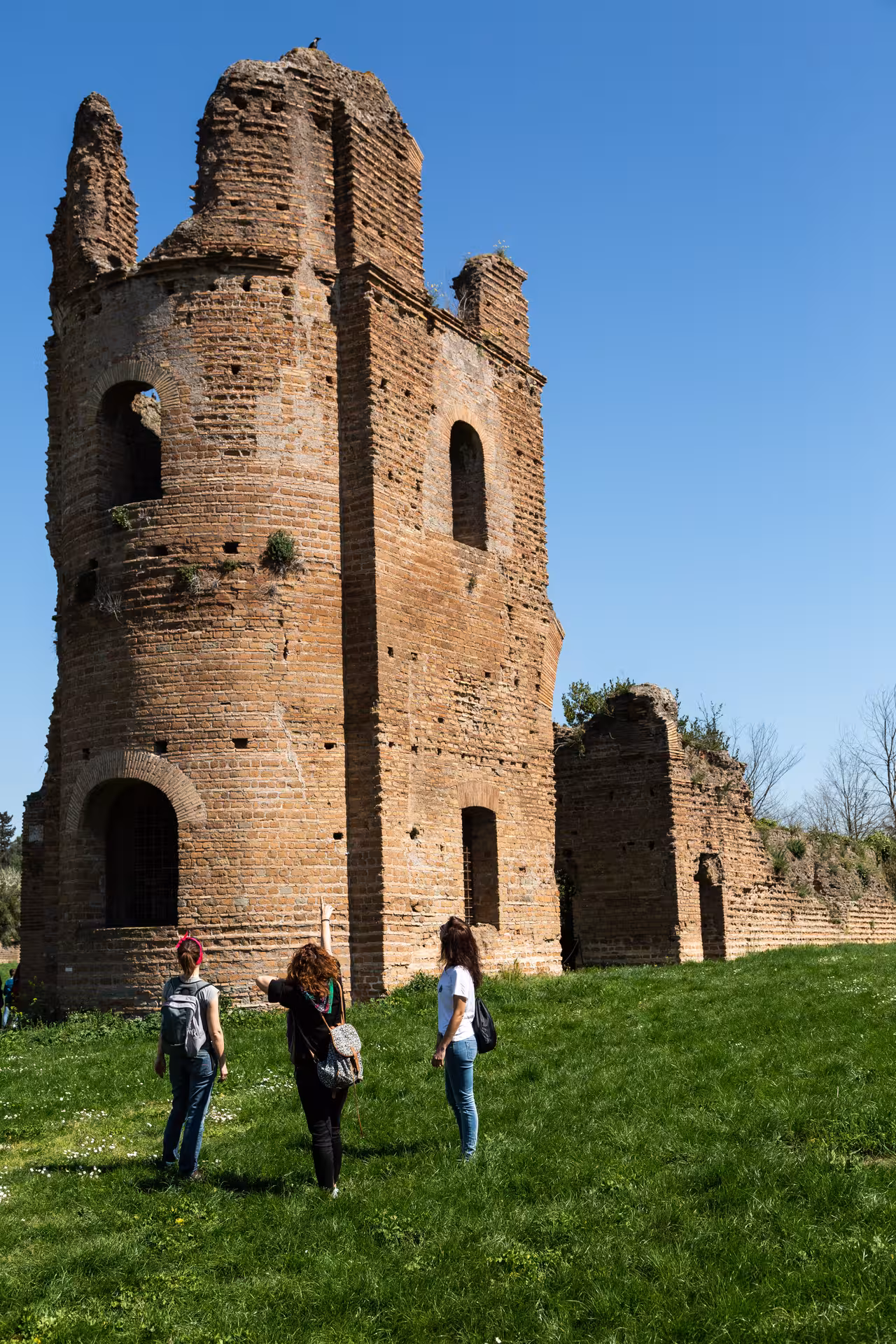 Visitors exploring an ancient Roman tower ruin on the Appian Way tour.