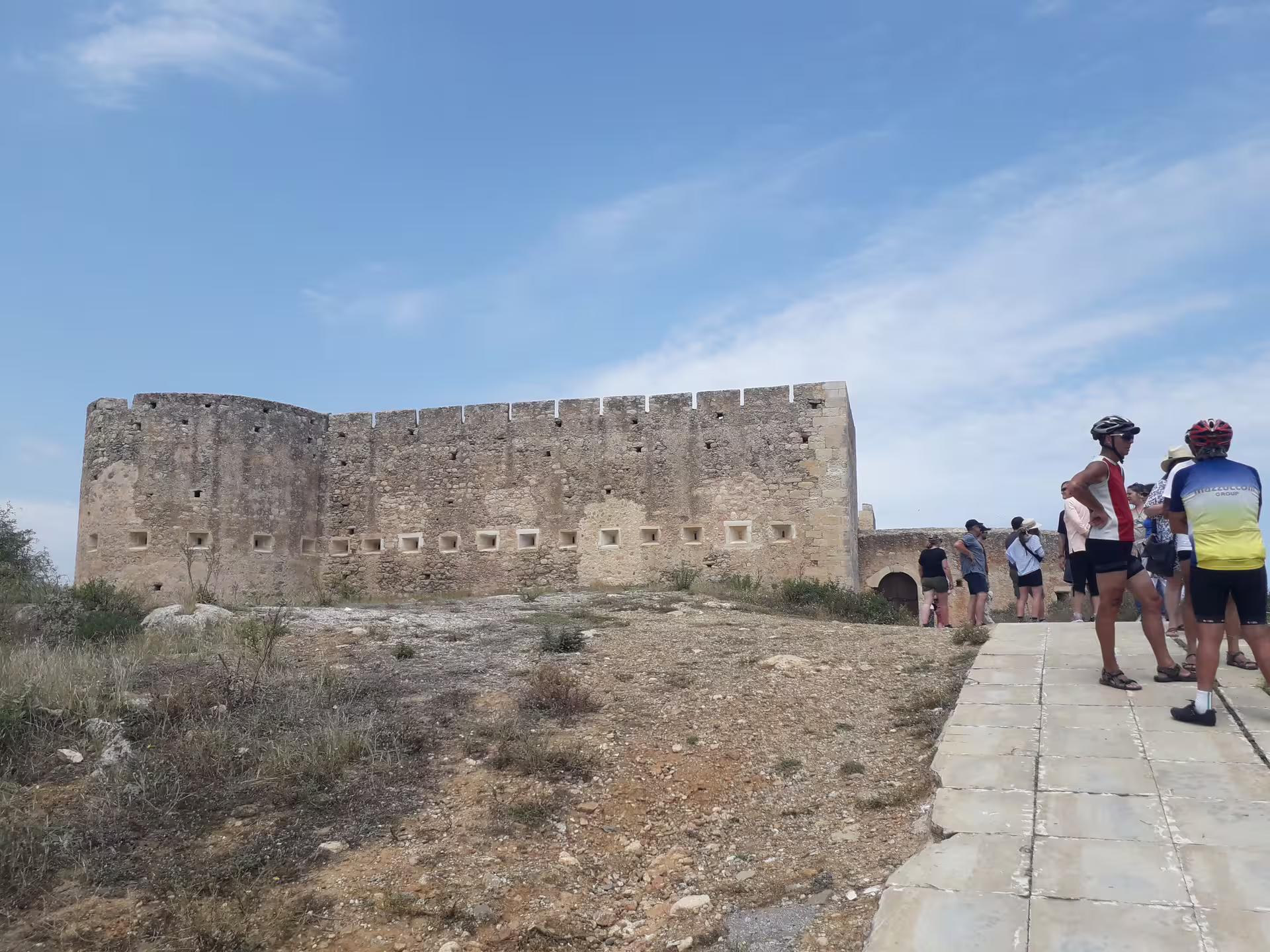 Visitors explore the ancient ruins of Aptera under a bright blue sky during the semi-private tour.