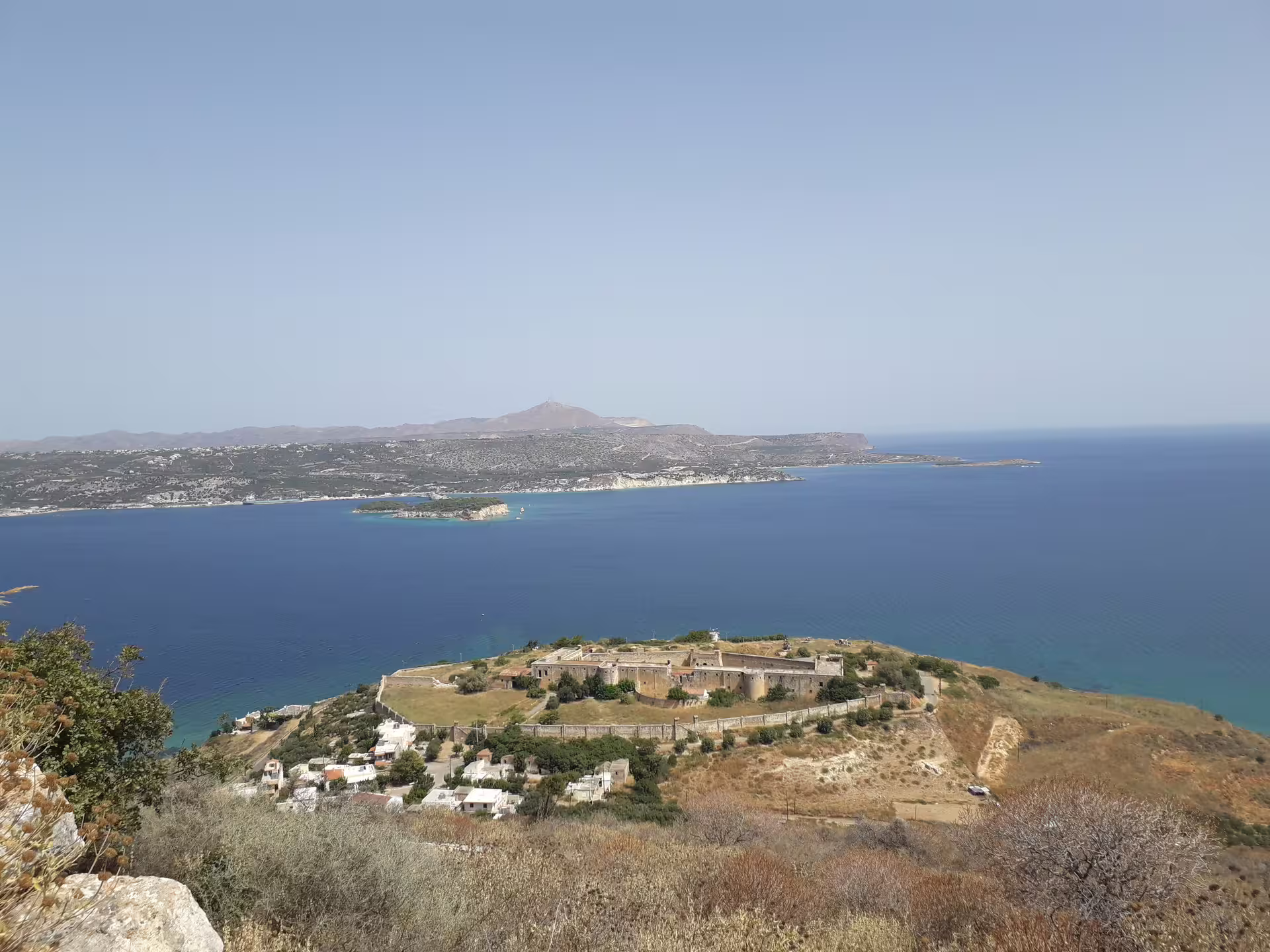 Stunning aerial view of Aptera ruins and Chania coastline under a clear blue sky.