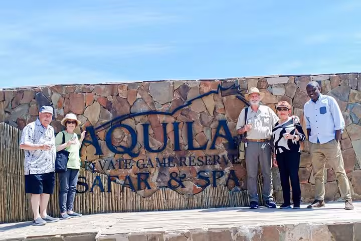Visitors posing at Aquila Game Reserve entrance, highlighting the safari and spa experience near Cape Town.