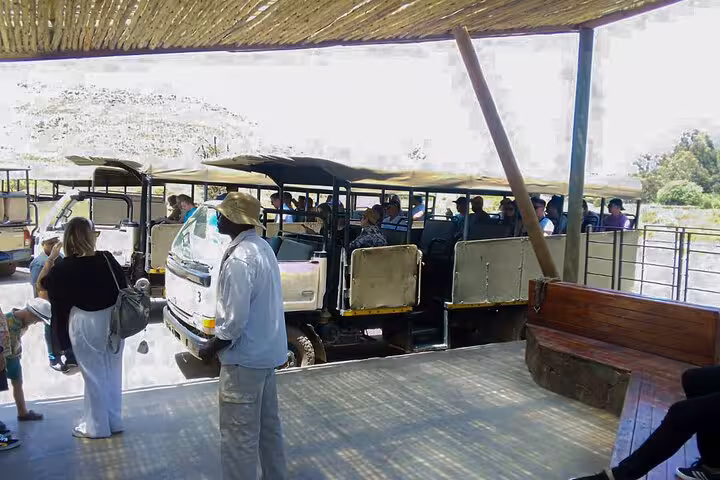 Tourists board safari vehicles at Aquila Game Reserve for an exciting wildlife adventure with wine tasting and lunch.