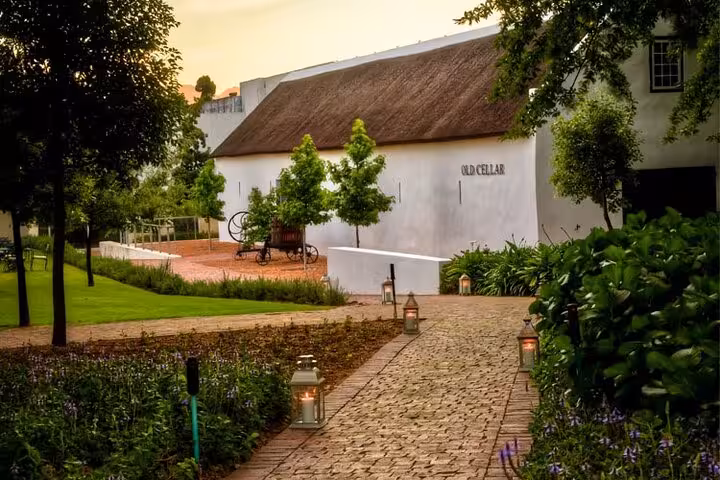 Charming wine cellar and lush garden pathway at Aquila Game Reserve, perfect for a serene wine tasting experience.