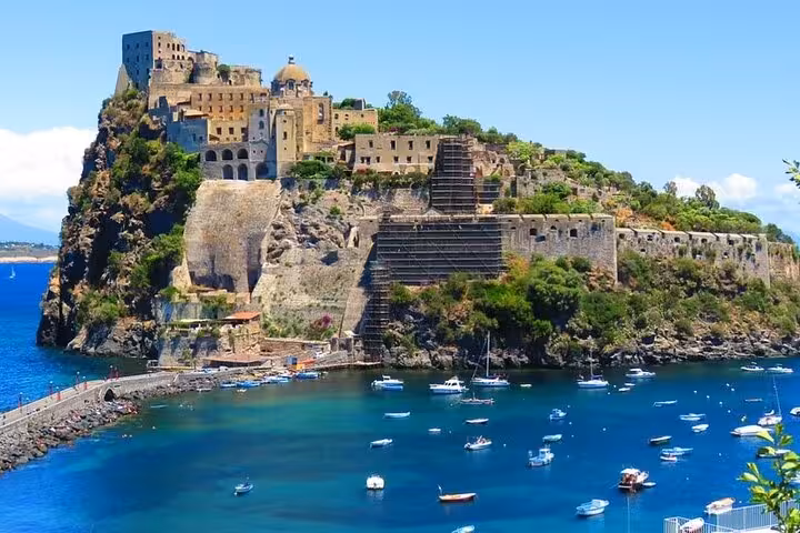 Historic Aragonese Castle perched on a rocky islet, surrounded by the blue waters of Ischia, Italy.