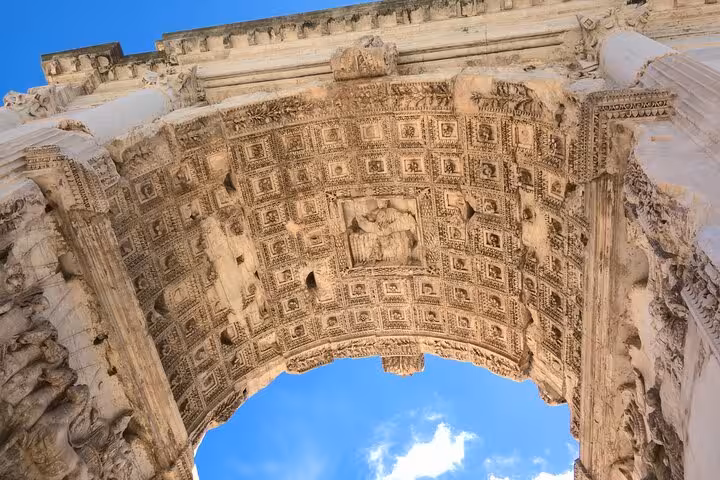 Intricate carvings on the Arch of Titus at the Roman Forum, showcasing ancient Roman architectural beauty.