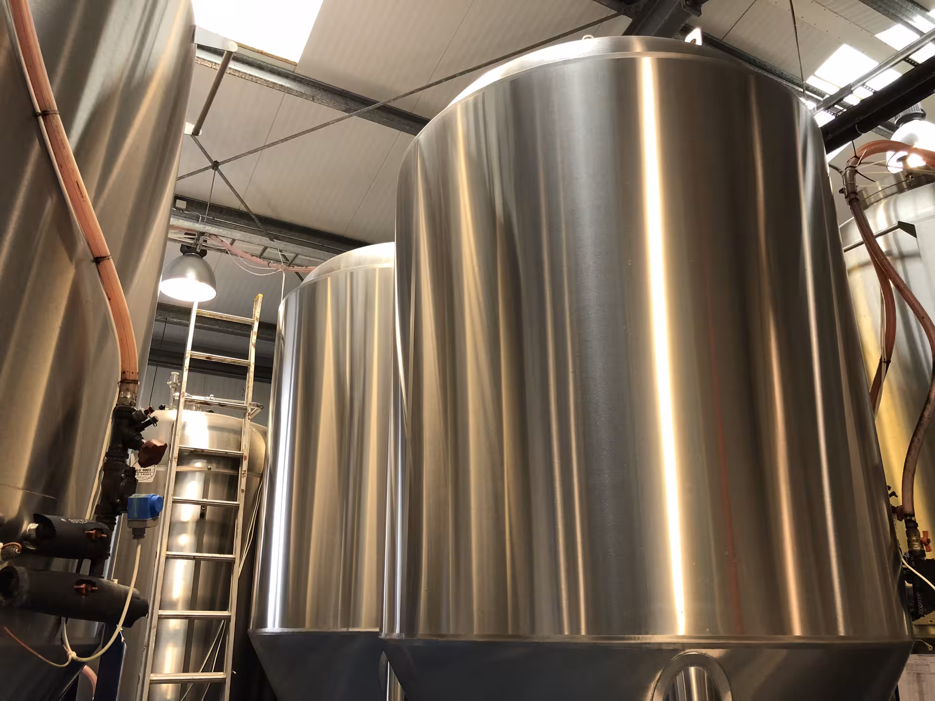 Industrial brewery equipment with large stainless steel tanks for Arctic cultural tour experience.