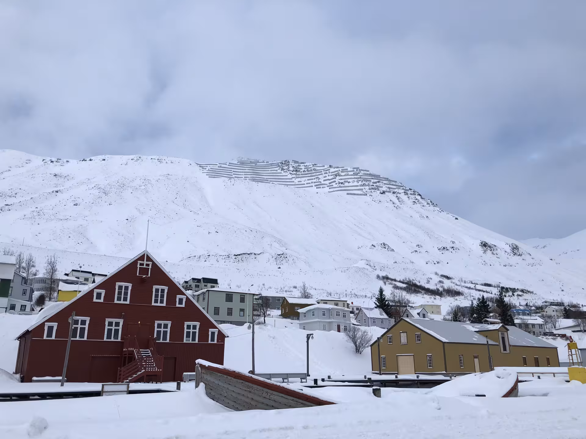 Charming Arctic village with colorful houses nestled against a snowy mountain backdrop, showcasing local culture.