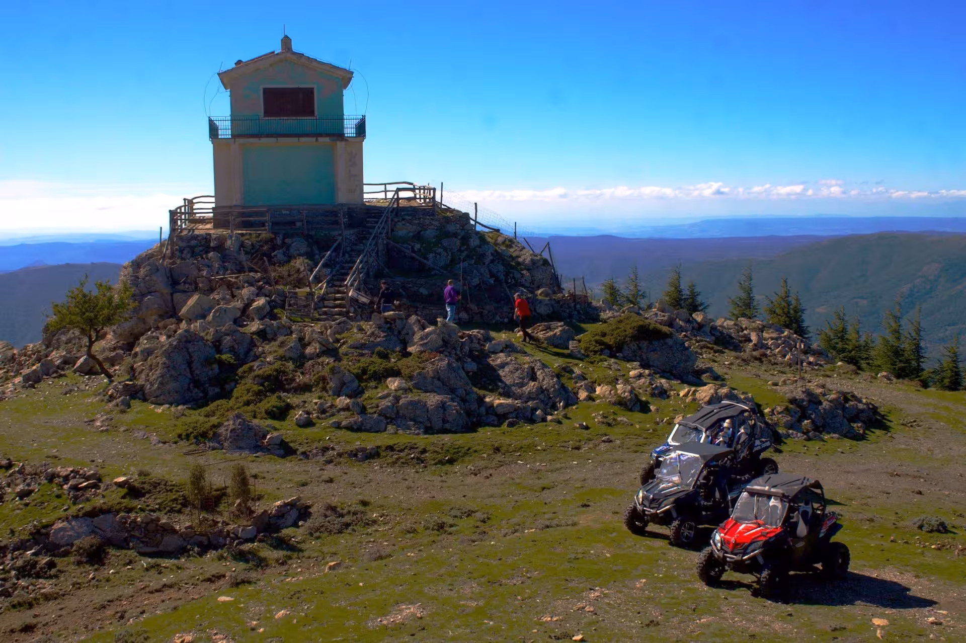 Buggies parked on a rocky hilltop near a scenic lookout during the Gennargentu buggy tour from Aritzo.