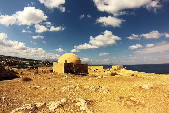 Stunning view of the Arkadi Monastery's dome against a vibrant sky, overlooking the serene Mediterranean Sea.