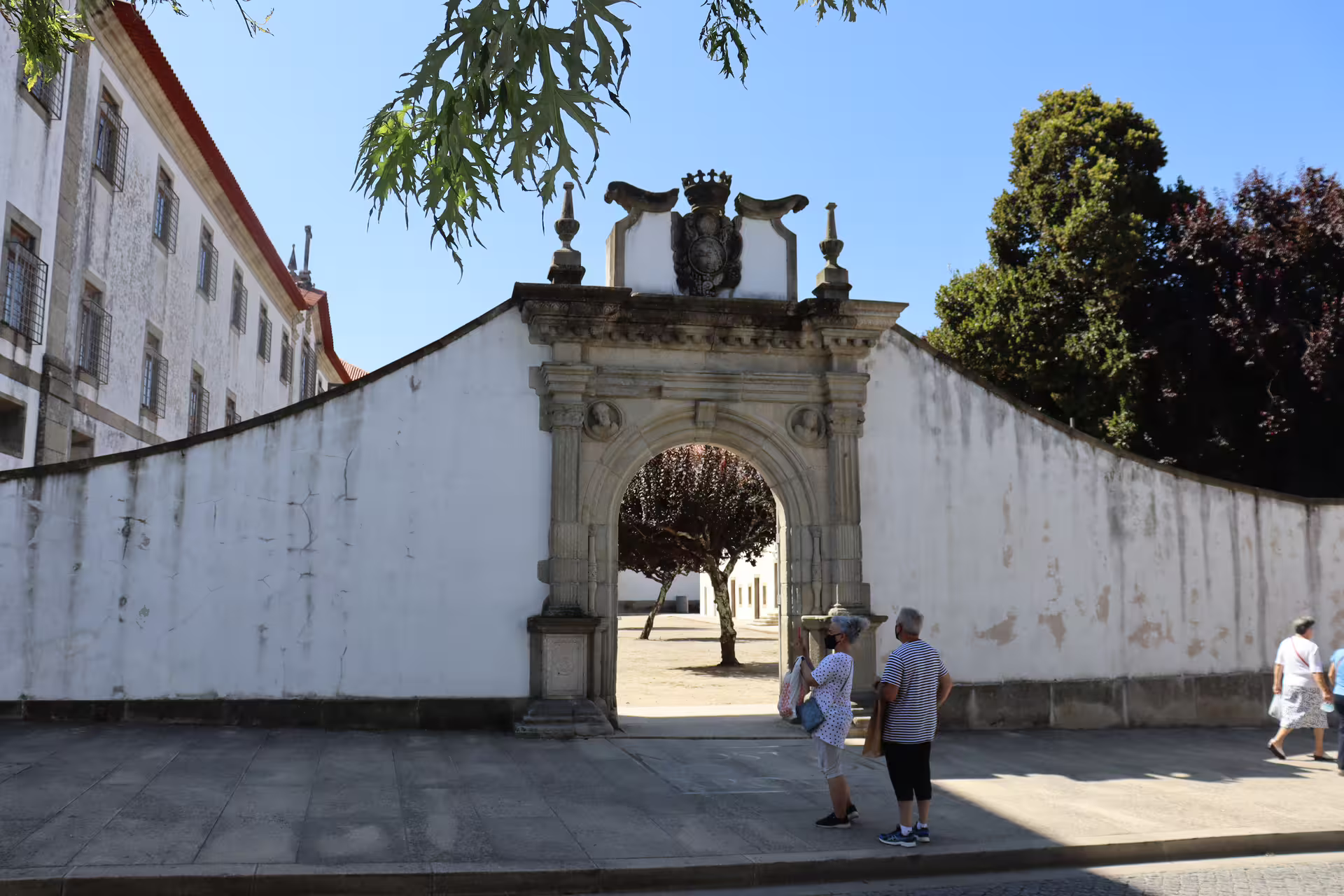 Historic archway at Arouca Monastery entrance, surrounded by visitors, highlighting the cultural aspect of the Arouca 516 Bridge and Paiva Walkways tour.