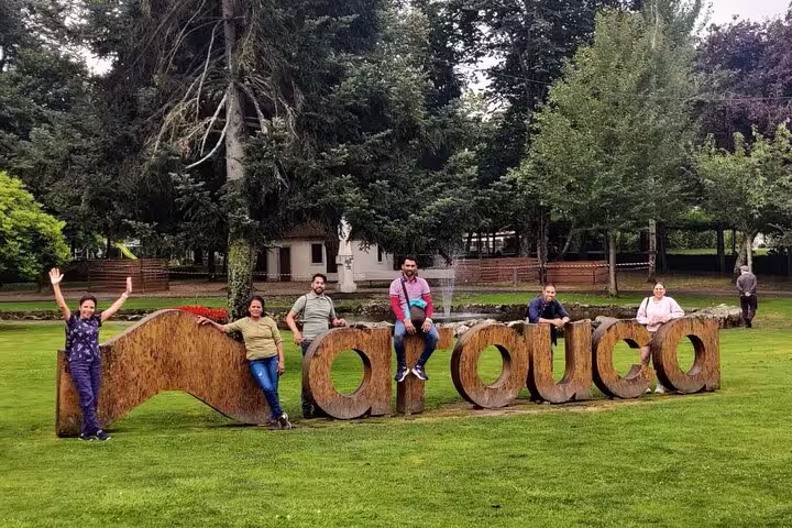 Group of tourists pose with the iconic Arouca sign, capturing memorable moments on the Arouca Suspension Bridge tour.
