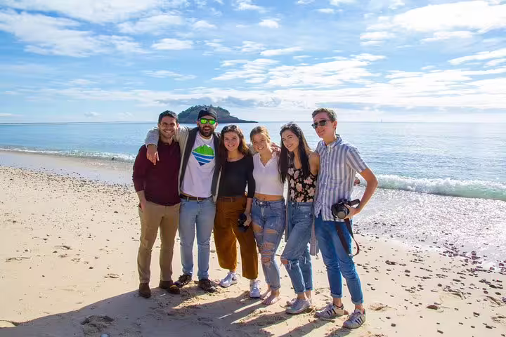 A group of friends enjoy a sunny day on the pristine beach of Arrábida, Portugal, capturing memories of this hidden paradise.