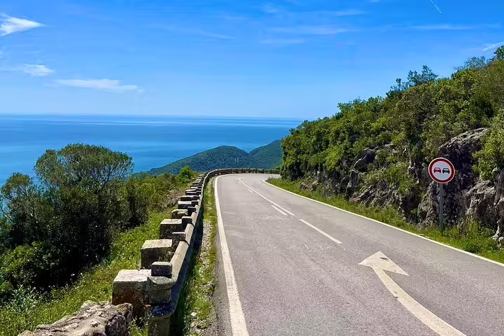 Scenic coastal road in Arrábida, Portugal, perfect for a 4X4 Jeep tour with stunning ocean views and lush greenery.