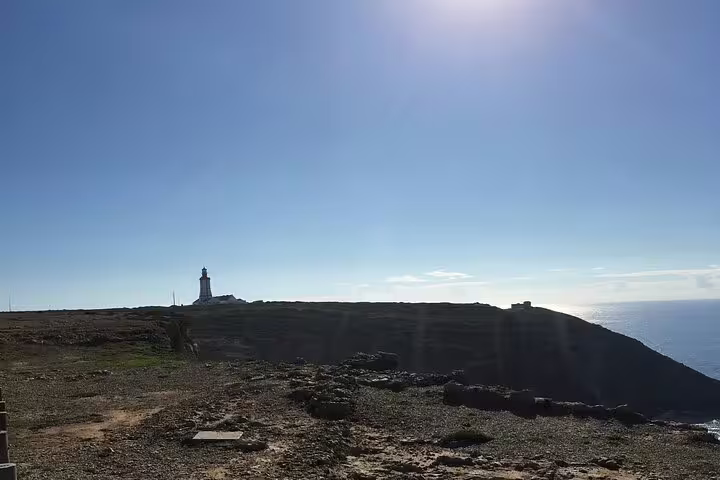 Scenic view of the Arrabida coastline with a lighthouse, perfect for a private day tour from Lisbon with wine tastings.