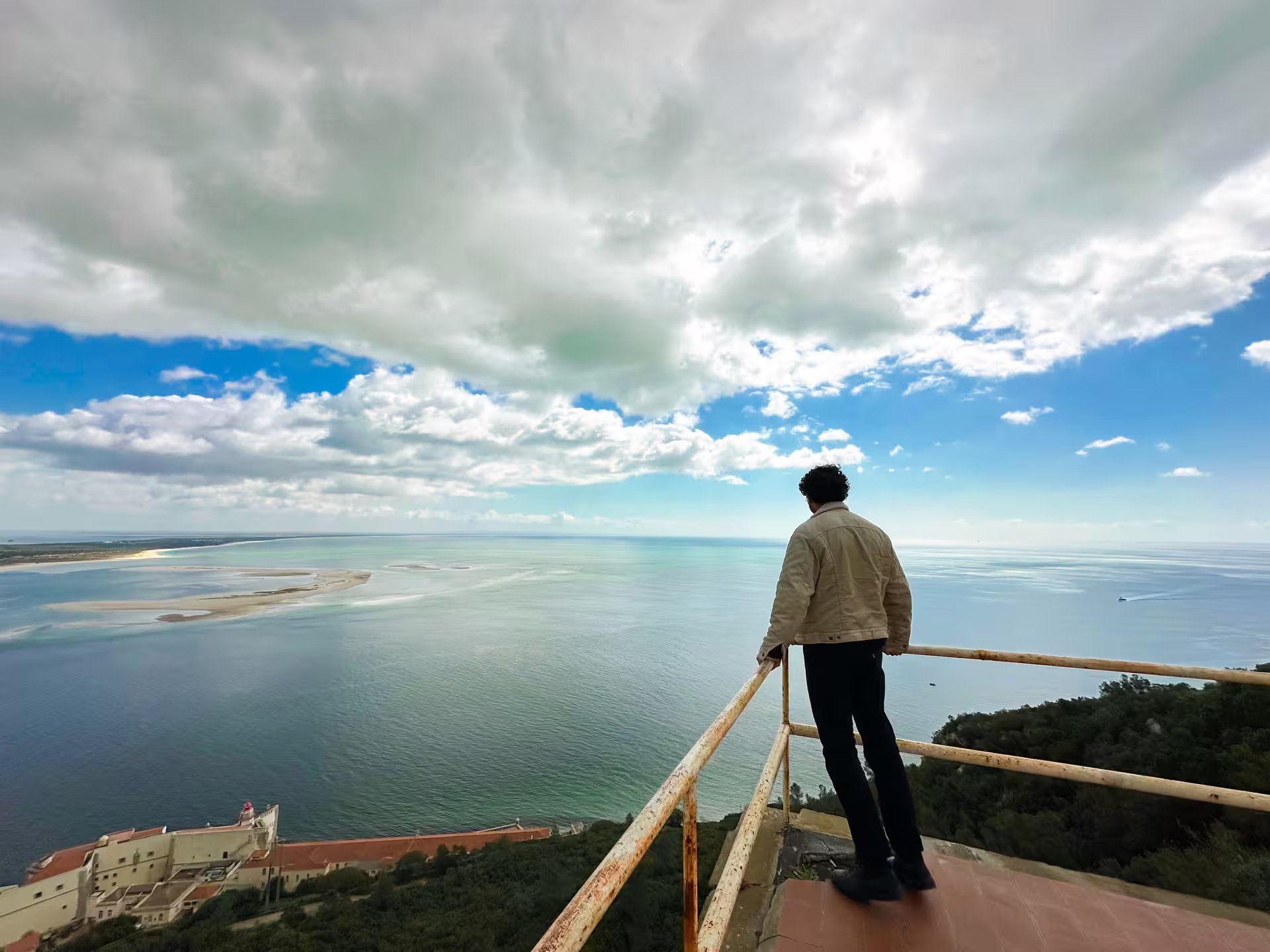 Scenic viewpoint over Arrábida's coastline, showcasing breathtaking ocean views and lush landscapes on a clear day.