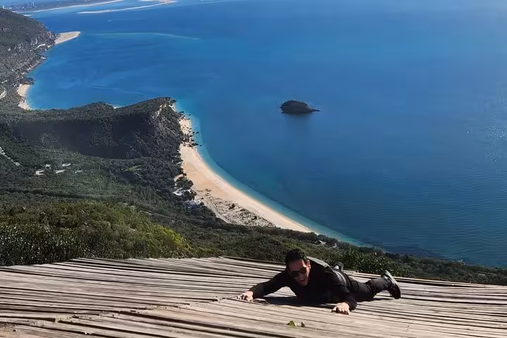 Tourist enjoying a panoramic vista over Arrábida's stunning coastline during a wine tour from Lisbon.