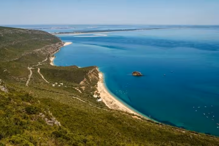 Scenic view of Arrábida coastline with lush greenery and turquoise waters, perfect for a wine tour from Lisbon.