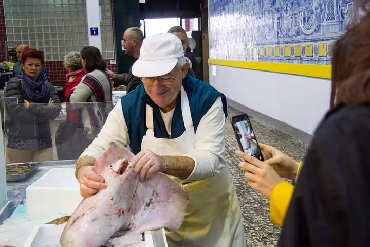 Local fishmonger displays fresh catch in bustling Arrábida market, capturing authentic Portuguese culture and culinary tradition.