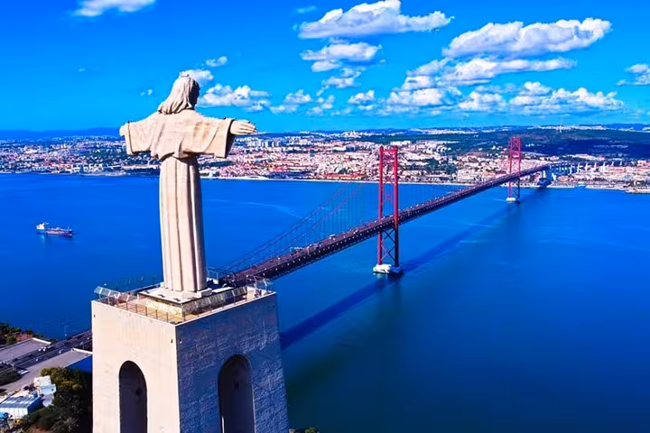 Scenic view of the iconic statue overlooking the 25 de Abril Bridge in Lisbon, a highlight of the Arrábida day tour.