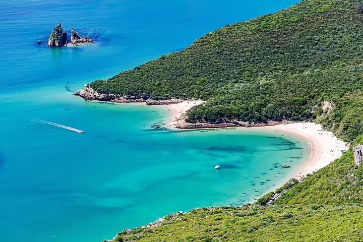 Scenic view of Arrábida Natural Park's turquoise waters and lush coastline, ideal for a Setúbal private tour adventure.