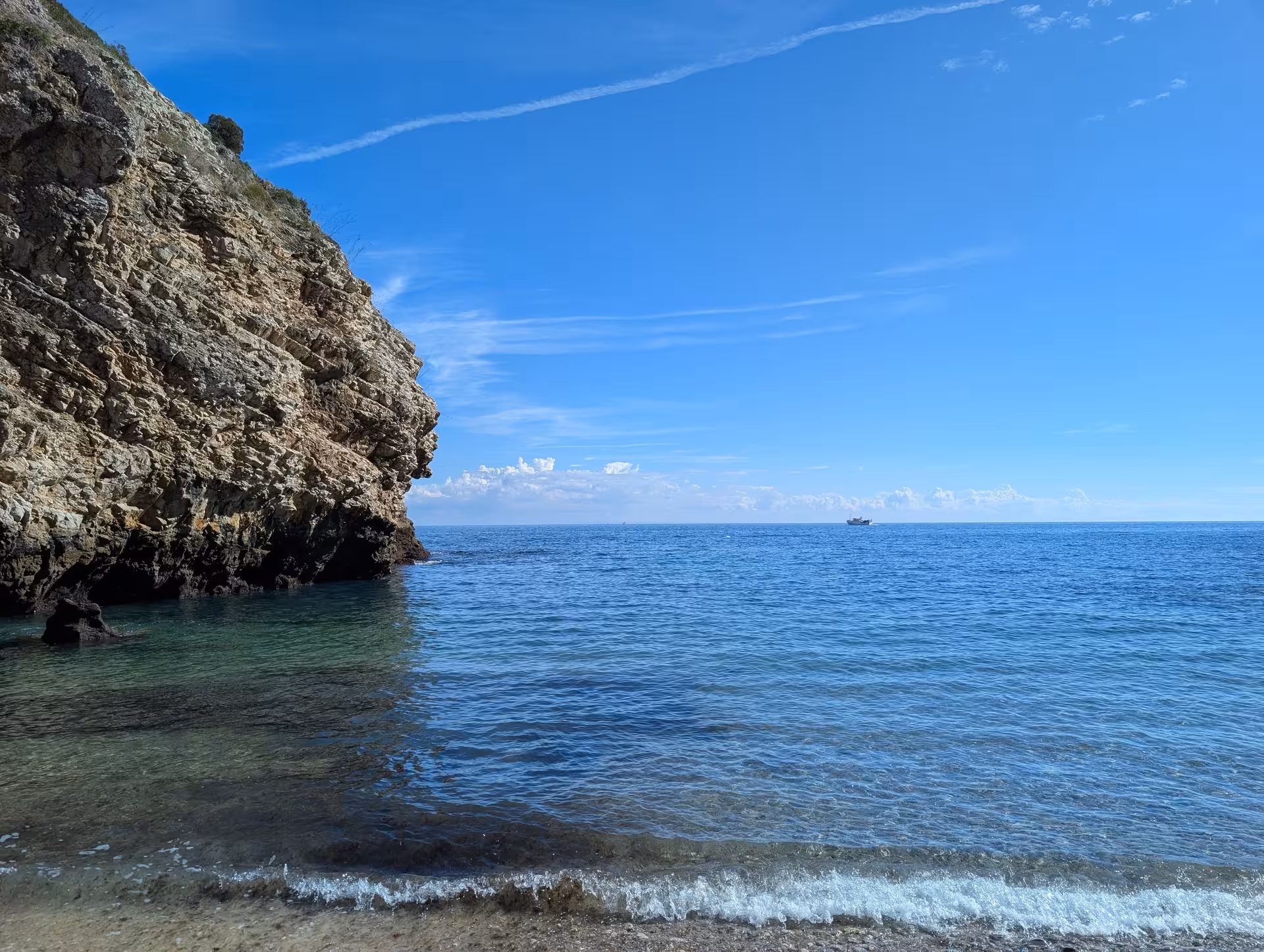 Rocky sea cliff and calm turquoise cove, serene stop on the Mindful Coastal Hike nature walk