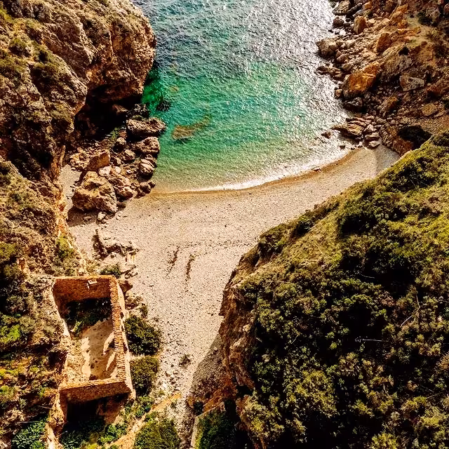 Turquoise cove and hidden pebble beach on mindful coastal hike, rugged cliffs and sea views