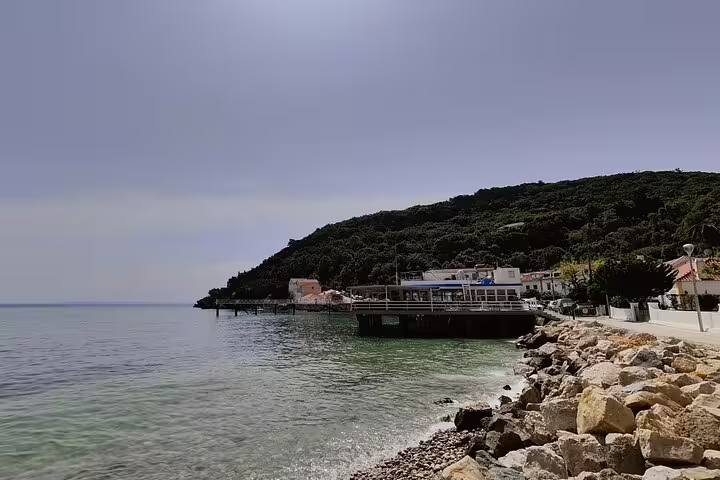 Scenic coastal view of Arrabida with lush hills and a charming waterfront, perfect for a day tour from Lisbon including wine tastings.