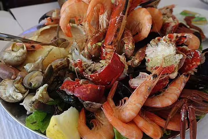 A vibrant seafood platter showcasing fresh shrimp, crab, and shellfish, perfect for a culinary experience on the Arrábida Sesimbra Setúbal tour.