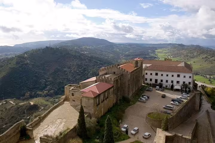 Panoramic view of Arrabida with historic castle and lush hills, a highlight of the private tour to Arrabida, Sesimbra, and Setubal.