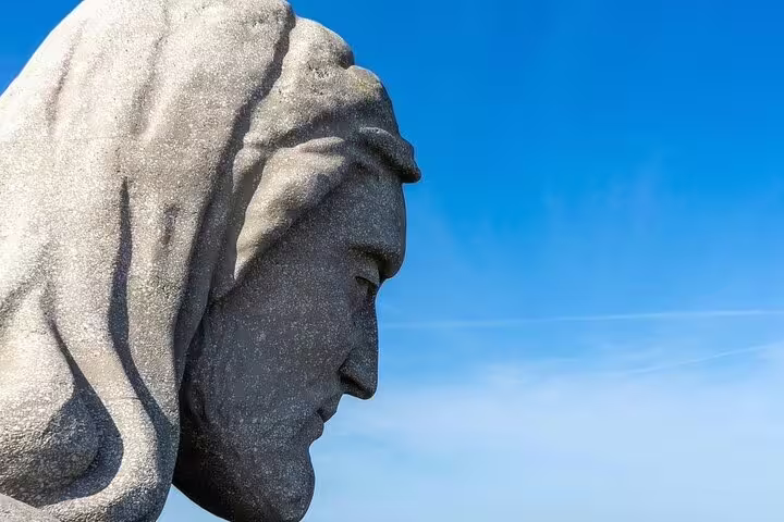 Close-up of a serene stone statue against a clear blue sky, highlighting the cultural heritage of Arrábida and Sesimbra.