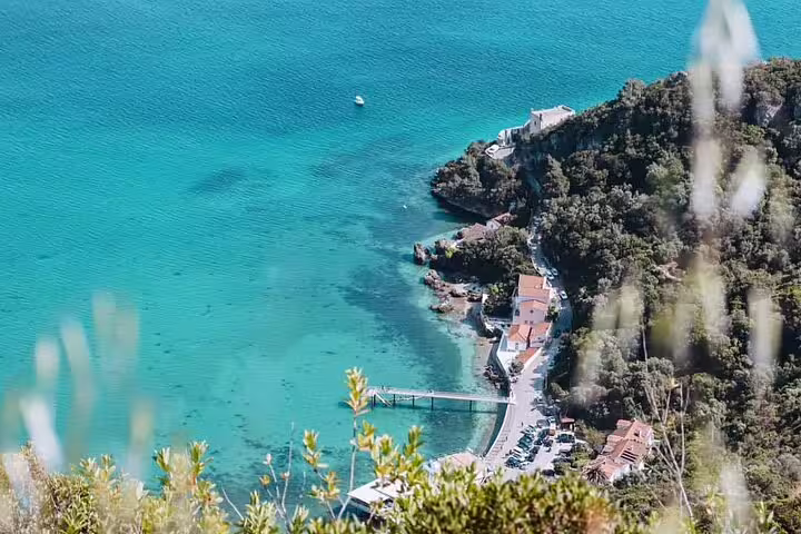 Aerial view of Arrábida's stunning turquoise waters and lush coastline, perfect for a Sesimbra day trip with wine tasting.