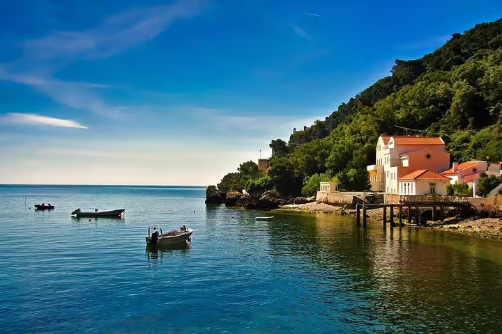 Serene coastal scenery with boats and lush greenery on the Blue Coast, highlighted in the Setúbal van tour.